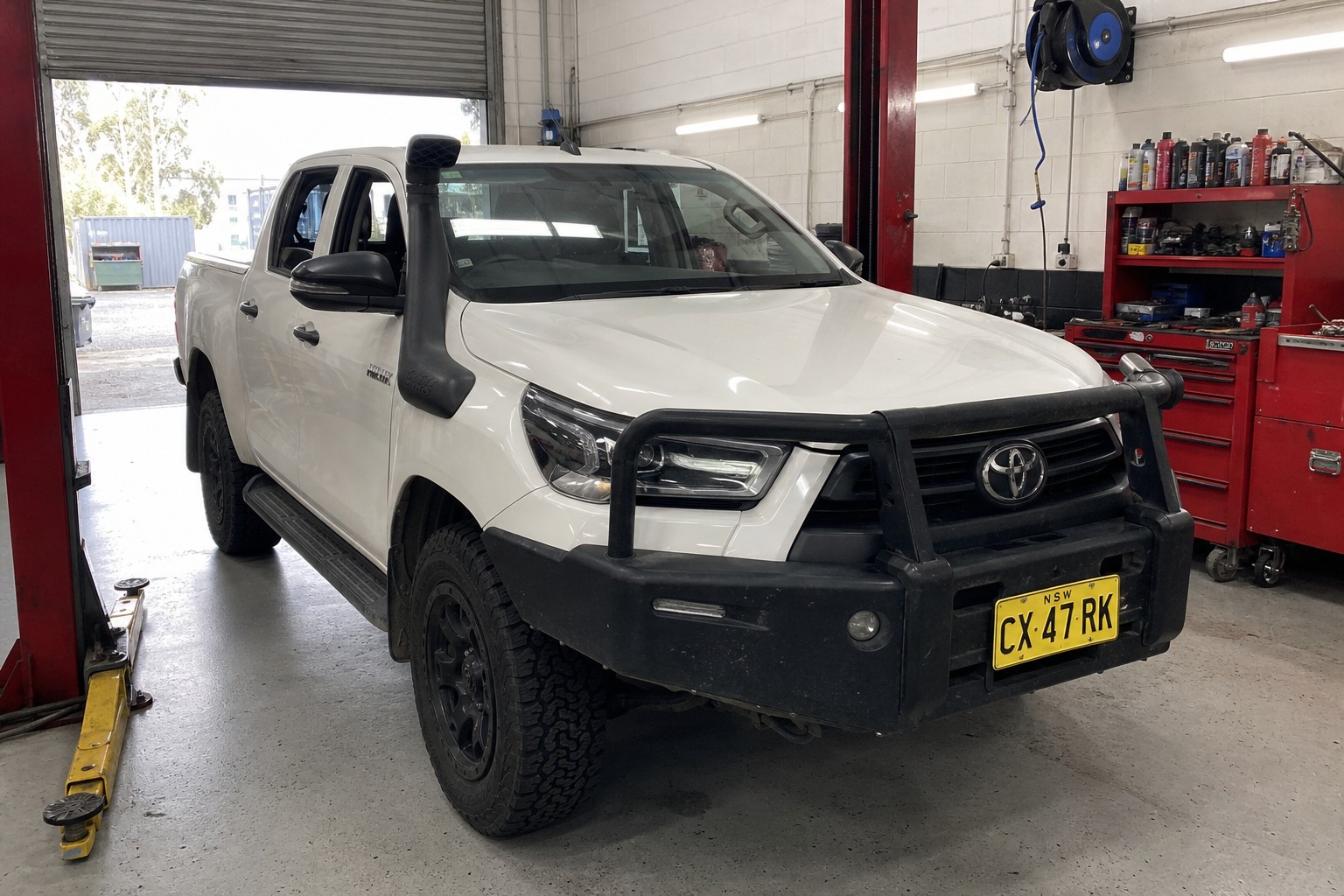 Front of a white HiLux, plate CX 47 RK